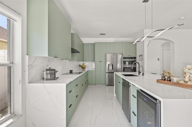 kitchen with marble finish floor, beverage cooler, a sink, stainless steel fridge, and green cabinets