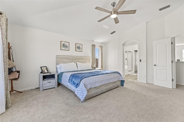 carpeted bedroom featuring arched walkways, visible vents, baseboards, and vaulted ceiling