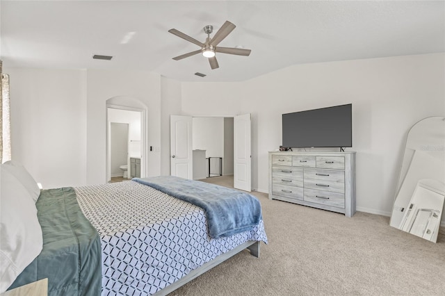 bedroom featuring visible vents, light colored carpet, lofted ceiling, arched walkways, and a ceiling fan