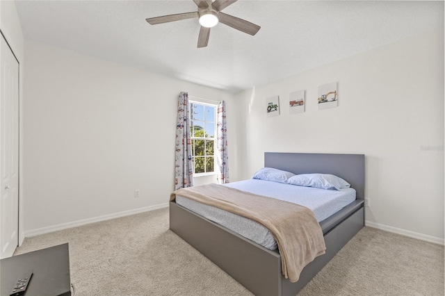 bedroom with a closet, ceiling fan, baseboards, and carpet