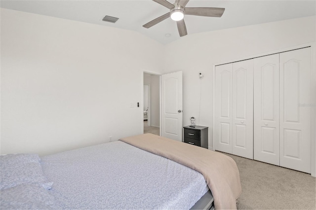 bedroom featuring visible vents, ceiling fan, vaulted ceiling, a closet, and light colored carpet