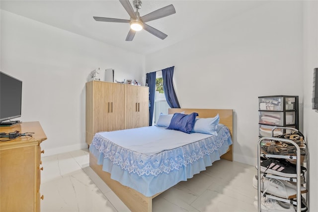 bedroom featuring baseboards, marble finish floor, and a ceiling fan