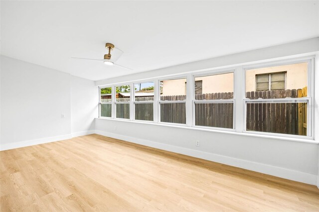 unfurnished sunroom with ceiling fan