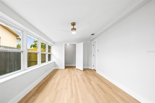 empty room with visible vents, baseboards, a ceiling fan, and light wood finished floors