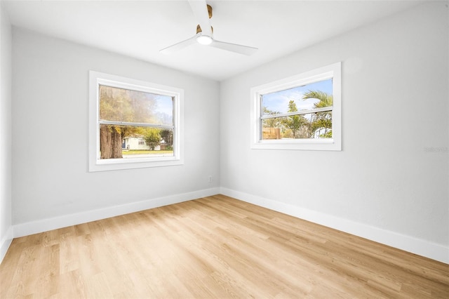 unfurnished room with baseboards, wood finished floors, and a ceiling fan