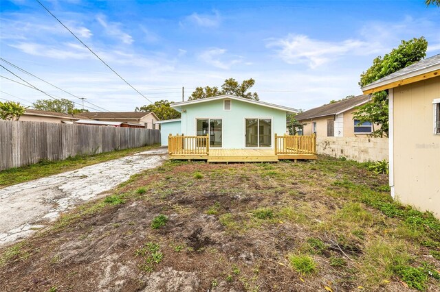 back of property with a wooden deck and fence