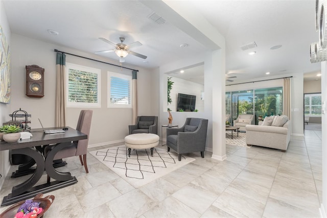 office area featuring baseboards, visible vents, a wealth of natural light, and ceiling fan