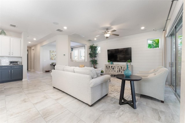 living area with recessed lighting, visible vents, and a healthy amount of sunlight