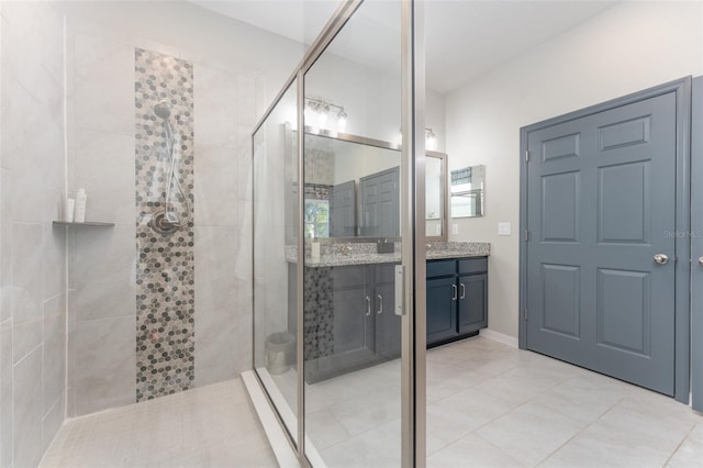 bathroom featuring tiled shower, vanity, and tile patterned flooring