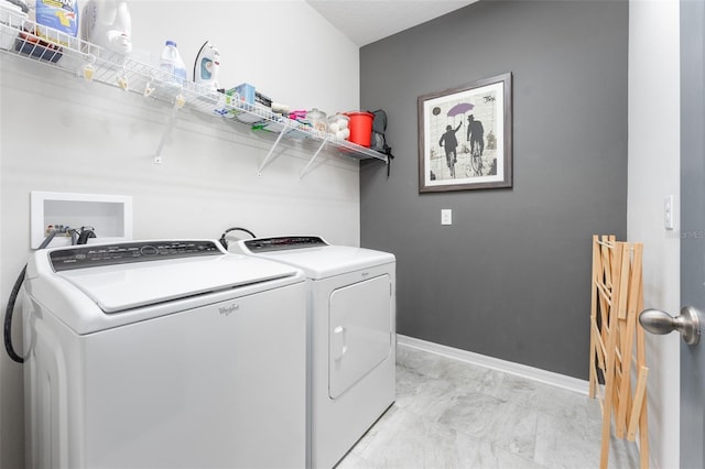 washroom featuring washer and clothes dryer, laundry area, and baseboards