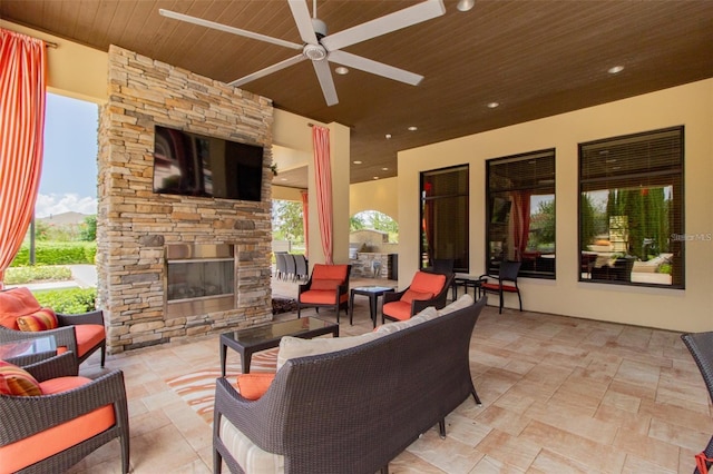 view of patio featuring a ceiling fan and an outdoor living space with a fireplace