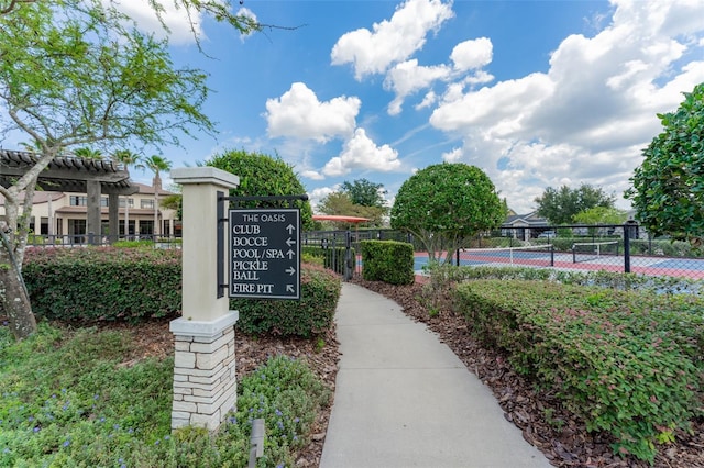 view of community with a tennis court and fence