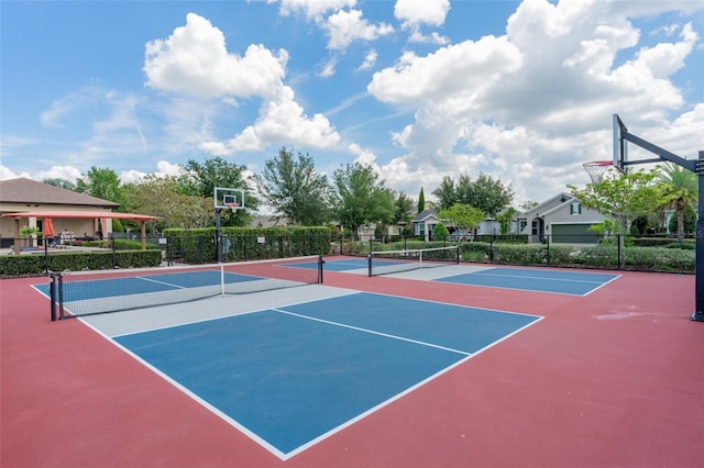 view of tennis court featuring community basketball court and fence