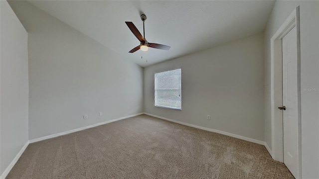 carpeted empty room with baseboards, lofted ceiling, and ceiling fan