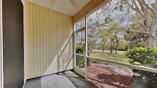 unfurnished sunroom with plenty of natural light and a ceiling fan