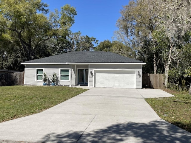 single story home featuring a front lawn, an attached garage, fence, and concrete driveway