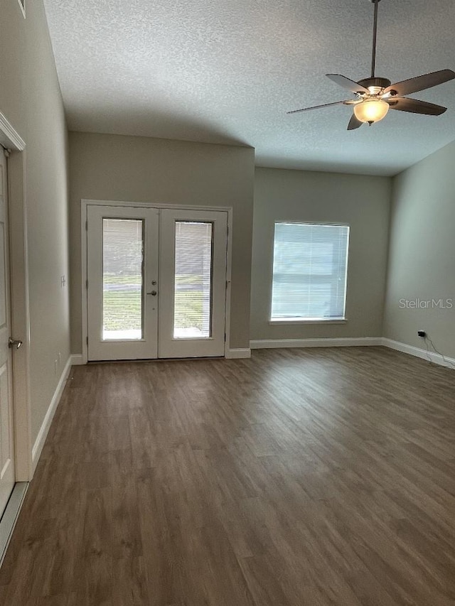 unfurnished room featuring wood finished floors, french doors, baseboards, and a textured ceiling