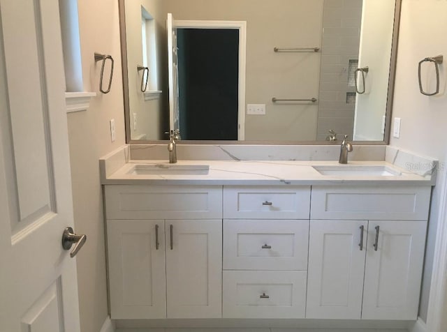 full bathroom featuring double vanity and a sink