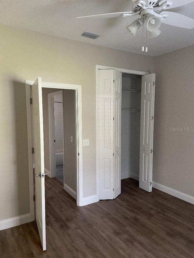 unfurnished bedroom with visible vents, baseboards, a closet, dark wood-style floors, and a ceiling fan