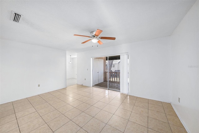 unfurnished room with light tile patterned flooring, a ceiling fan, visible vents, and a textured ceiling