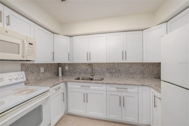 kitchen with a sink, white appliances, backsplash, and white cabinetry