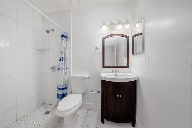 bathroom with vanity, toilet, marble finish floor, and a tile shower