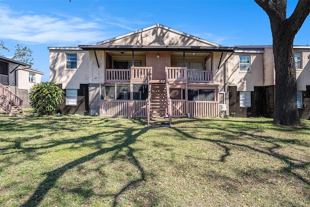 back of property with stairway, brick siding, and a lawn