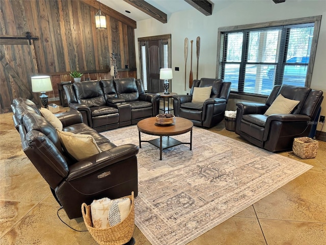 living area with beam ceiling, wooden walls, and a barn door