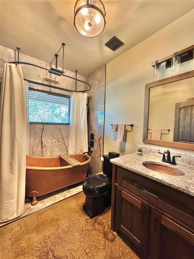 full bathroom with vanity, toilet, and visible vents