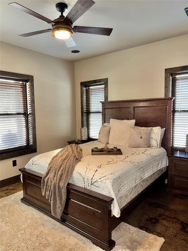 carpeted bedroom with baseboards and ceiling fan