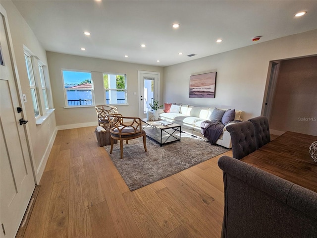 living area featuring recessed lighting, baseboards, and wood finished floors