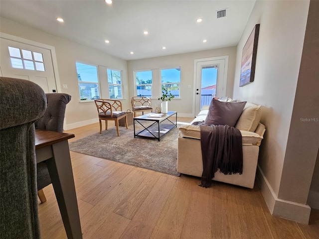 living room with light wood-style flooring, recessed lighting, visible vents, and baseboards