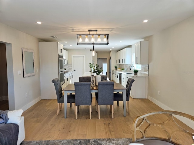 dining room with recessed lighting, visible vents, light wood finished floors, and baseboards