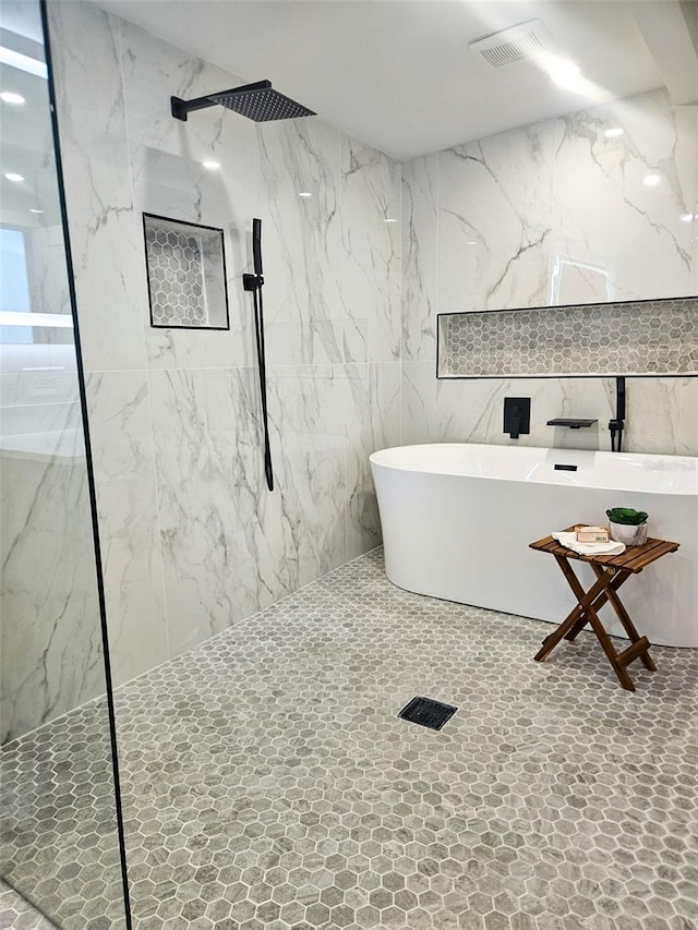 full bathroom with a marble finish shower and visible vents