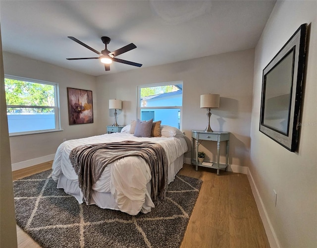 bedroom featuring a ceiling fan, baseboards, and wood finished floors