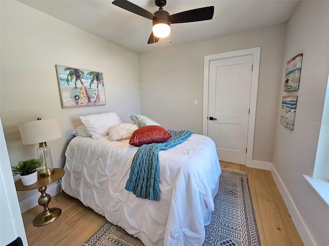 bedroom with ceiling fan, baseboards, and light wood-style flooring