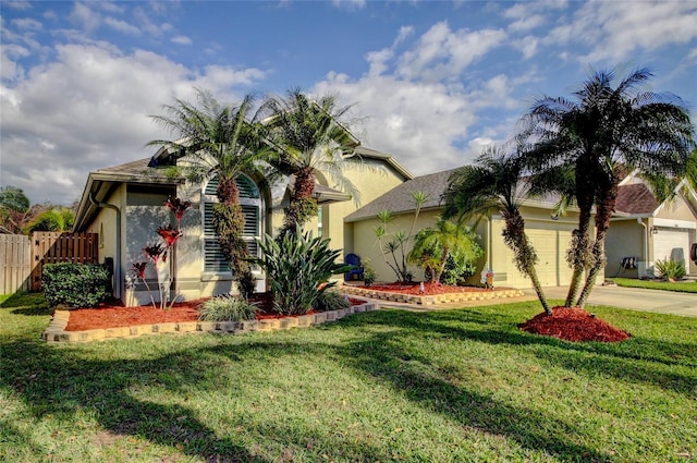 view of front of home with fence, stucco siding, concrete driveway, a front lawn, and a garage