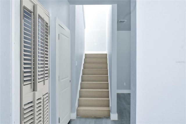 stairway featuring visible vents and baseboards