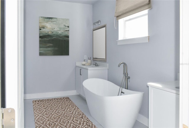 full bathroom with vanity, baseboards, and a freestanding bath