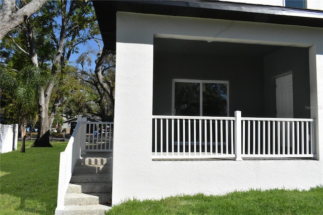 view of side of home featuring a lawn and stucco siding