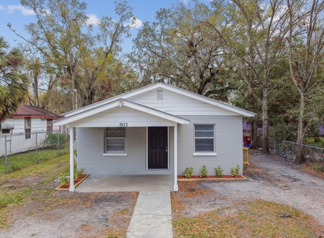 bungalow featuring concrete block siding and fence