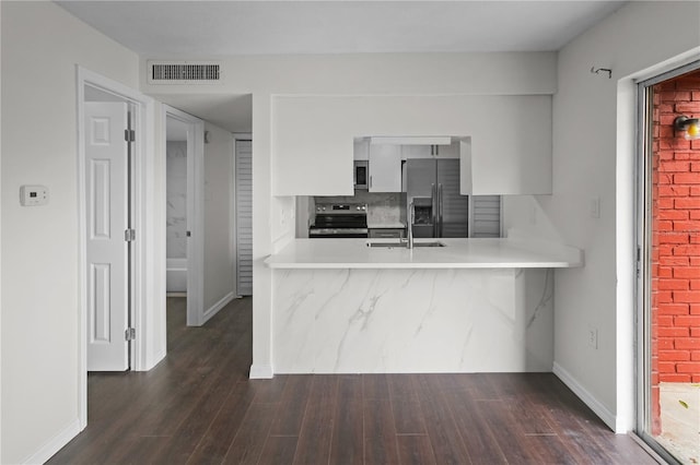 kitchen with visible vents, a sink, stainless steel appliances, a peninsula, and light countertops