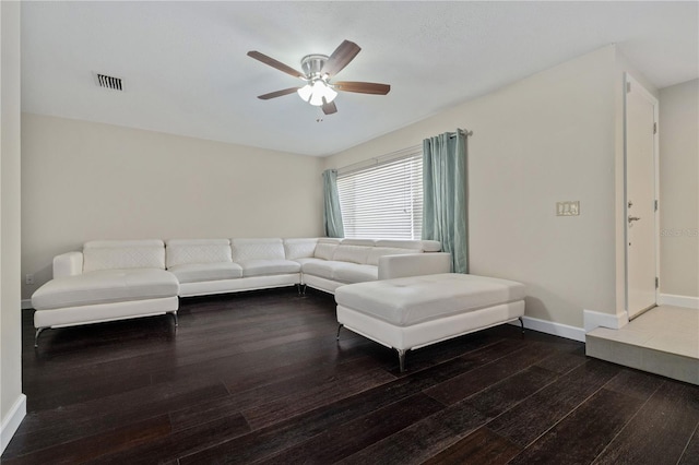 living room featuring visible vents, wood-type flooring, baseboards, and ceiling fan