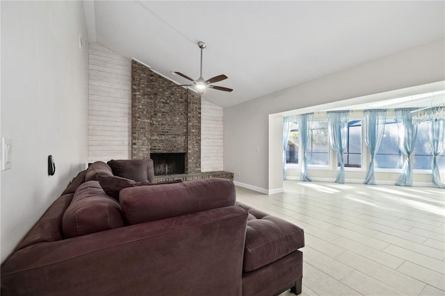 living room with high vaulted ceiling, light wood-style flooring, baseboards, a brick fireplace, and ceiling fan