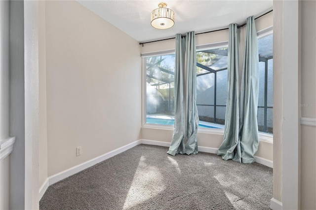 carpeted empty room with baseboards