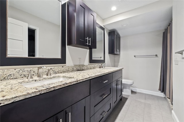 full bathroom featuring baseboards, double vanity, recessed lighting, a sink, and toilet