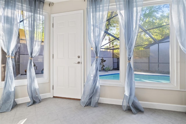 interior space featuring tile patterned floors, a healthy amount of sunlight, and baseboards