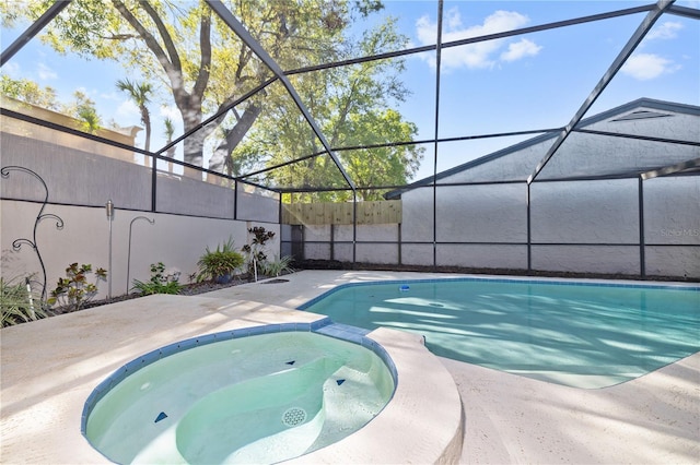 view of swimming pool featuring a lanai, fence, a pool with connected hot tub, and a patio