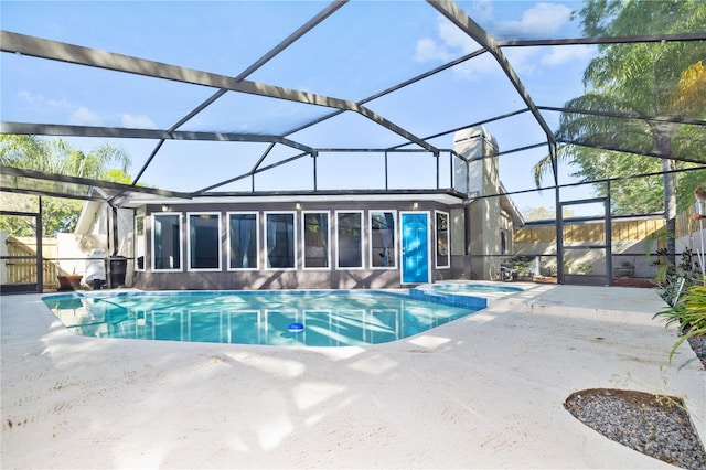 view of pool with a pool with connected hot tub, a lanai, and a patio area