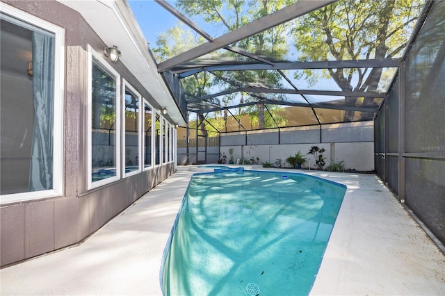 view of pool featuring glass enclosure, a pool with connected hot tub, and a patio